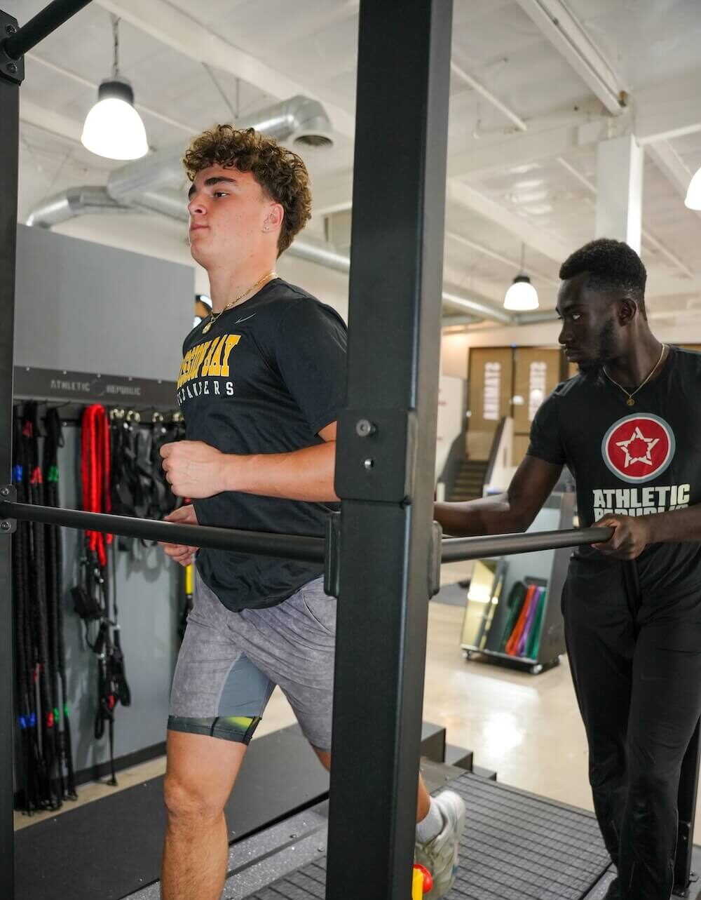 student athlete training with coach on treadmill